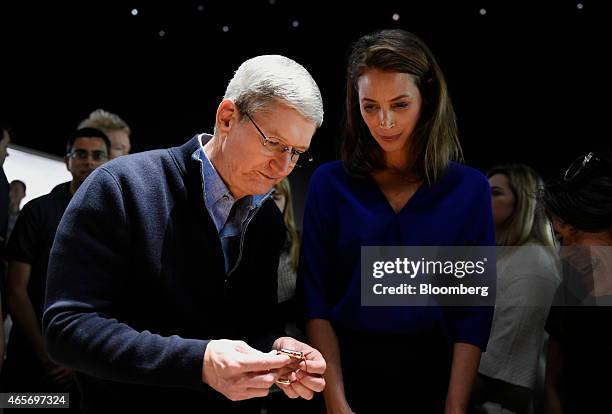 Tim Cook, chief executive officer of Apple Inc., left, views the Apple Watch with model Christy Turlington Burns at the Apple Inc. Spring Forward...