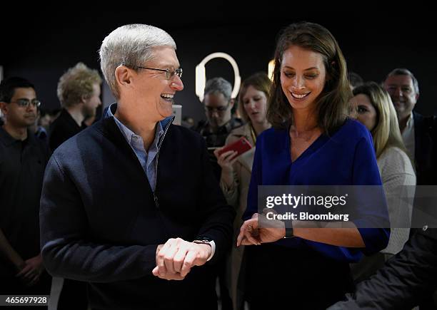 Tim Cook, chief executive officer of Apple Inc., left, views the Apple Watch with model Christy Turlington Burns at the the company's Spring Forward...