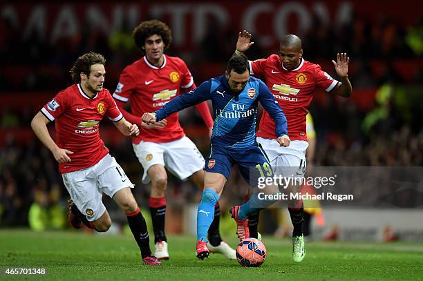 Santi Cazorla of Arsenal is closed down by Daley Blind , Marouane Fellaini and Ashley Young of Manchester United during the FA Cup Quarter Final...