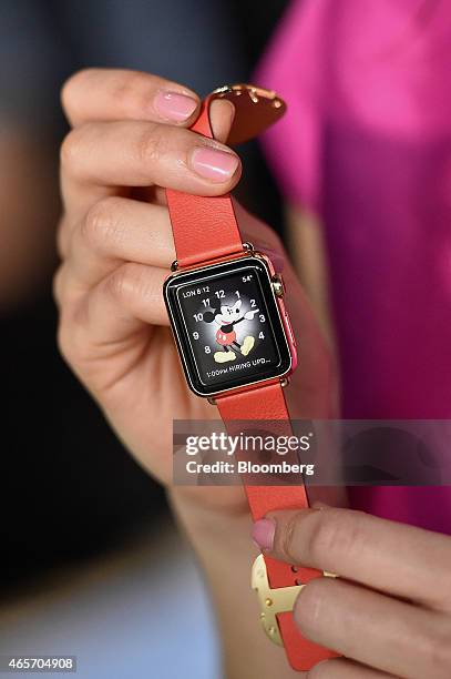 An attendee displays the Apple Watch Edition for a photograph during the Apple Inc. Spring Forward event in San Francisco, California, U.S., on...