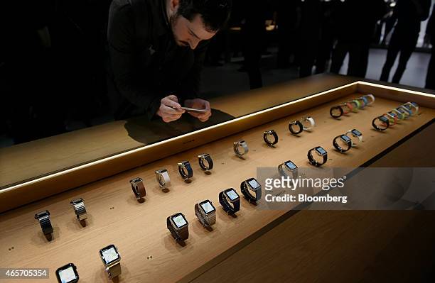 An attendee takes a photograph with an iPhone of the Apple Watches during the Apple Inc. Spring Forward event in San Francisco, California, U.S., on...