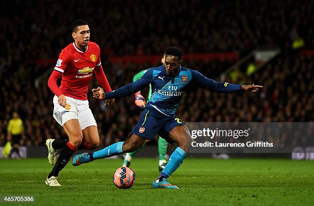 Danny Welbeck of Arsenal scores his team's second goal despite the attentions from Chris Smalling of Manchester United during the FA Cup Quarter...
