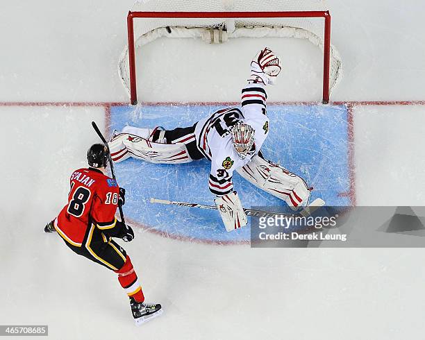 Matt Stajan of the Calgary Flames scores on Antti Raanta of the Chicago Blackhawks during an NHL game at Scotiabank Saddledome on January 28, 2014 in...