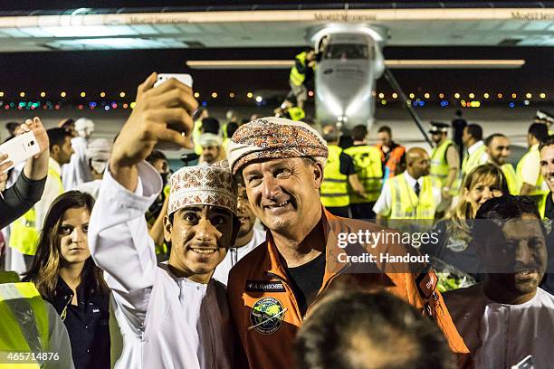 In this handout image supplied by Jean Revillard, pilot Andre Boschberg is photographed with a local well-wisher after Solar Impulse 2, a...