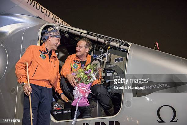In this handout image supplied by Jean Revillard, pilot Andre Boschberg , and tomorrow's pilot Bertrant Piccard talk after Solar Impulse 2, a...