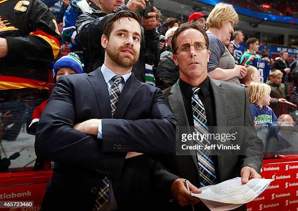 Assistant coach Ben Cooper and Assistant coach Doug Lidster of the Vancouver Canucks watch warmup for their NHL game against the Anaheim Ducks at...