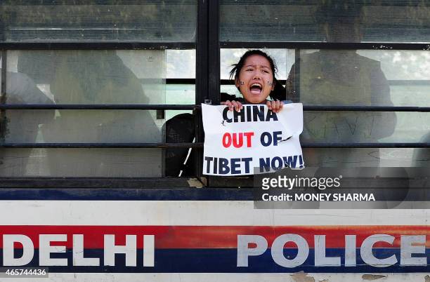 Tibetan exile shouts anti-China slogans after being detained by Indian police during a protest outside the Chinese embassy in New Delhi on March 10,...