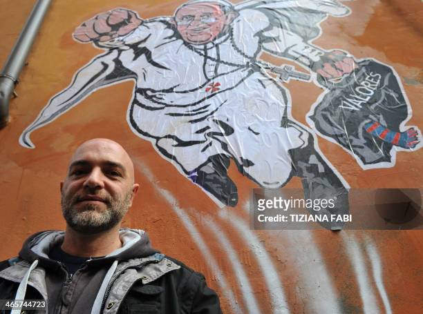 Italian street artist Maupal poses in front of his street art mural showing Pope Francis as a superman, flying through the air with his white papal...