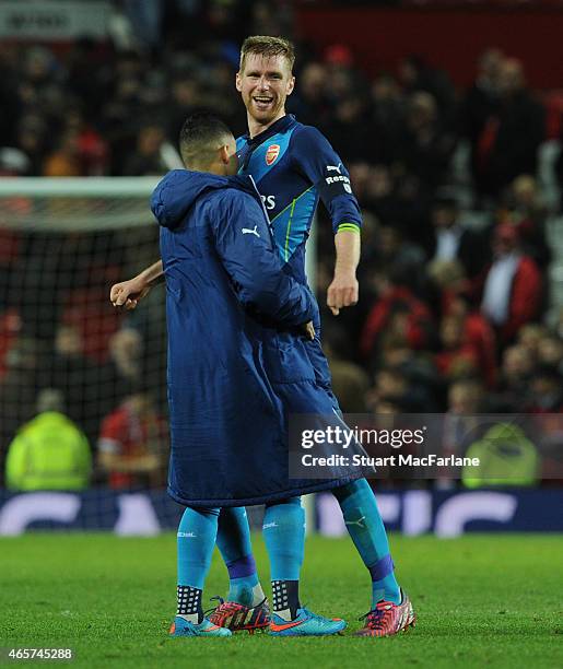 Per Mertesacker celebrates Arsenal victory with Alex Olxade-Chamberlain after the FA Cup Quarter Final between Manchester United and Arsenal at Old...