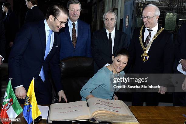 Crown Princess Victoria of Sweden and Prince Daniel of Sweden sign the 'steelbook' of Essen as mayor Reinhard Pass looks on during their visit in...