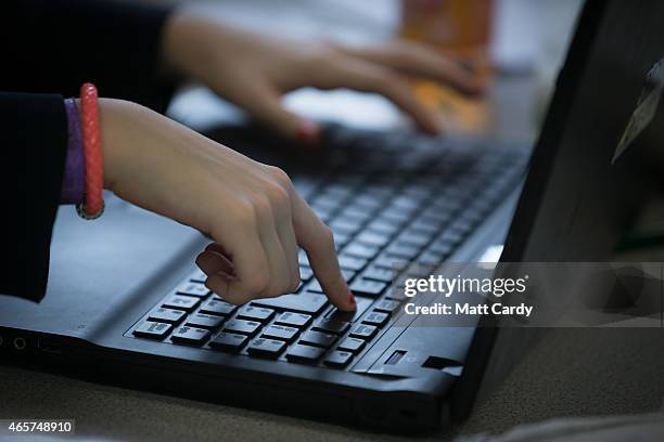 Pupil uses a laptop computer during a english lesson at the Ridings Federation Winterbourne International Academy in Winterbourne near Bristol on...