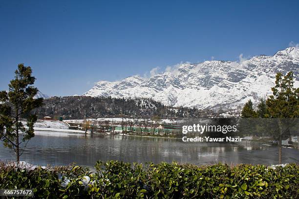 Snow capped Zabarvan mountains are reflected in a pond on March 10, 2015 in Srinagar, the summer capital of Indian administered Kashmir, India....