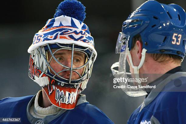 Goaltender Evgeni Nabokov of the New York Islanders looks to teammate Casey Cizikas during the 2014 NHL Stadium Series practice session at Yankee...