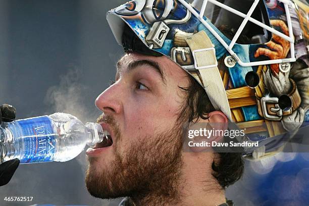 Goaltender Kevin Poulin of the New York Islanders takes a drink of water during the 2014 NHL Stadium Series practice session at Yankee Stadium on...