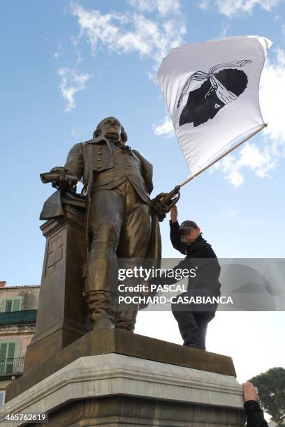 Young Corsican nationalist hangs a Corsican flag on the statue of Pascal Paoli on January 29, 2014 in Corte, Northern Corsica, during a demonstration...