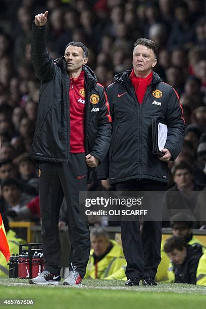 Manchester United's Dutch manager Louis van Gaal and Manchester United's Welsh assistant manager Ryan Giggs give instructions to their players during...