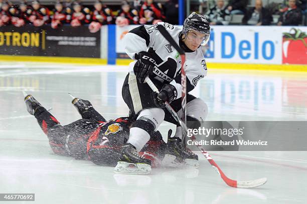 Danick Martel of the Blainville-Boisbriand Armada skates with the puck in front of a falling Matthieu Desautels of the Baie Comeau Drakkar during the...