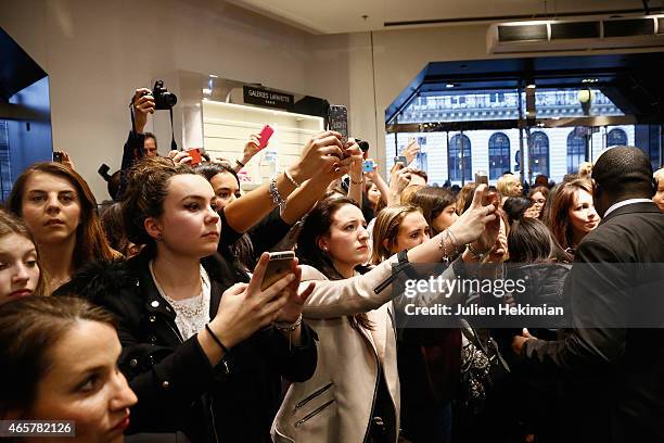 Fans attend the Yves Saint Laurent Beauty with Cara Delevingne celebrating the luxurious mascara for a false lash effect at Galeries Lafayette on...