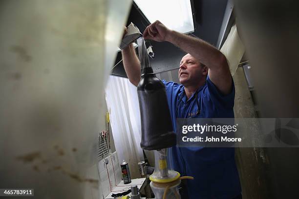 Prosthetist Edward Sliwinski pours resin while constructing a custom leg socket for a U.S. Military veteran amputee at the Veterans Administration ,...