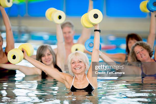 grupo de jubilados haciendo ejercicios aeróbicos en el agua - deporte acuático fotografías e imágenes de stock