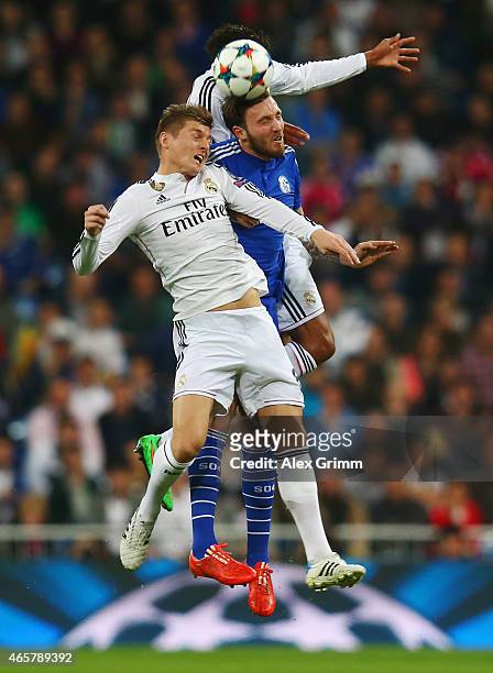 Marco Hoeger of Schalke jumps between Raphael Varane and Toni Kroos of Real Madrid CF during the UEFA Champions League Round of 16 second leg match...