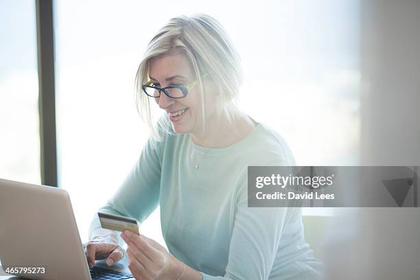 woman shopping online with credit card - red blouse fotografías e imágenes de stock