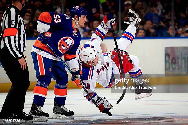 Jesper Fast of the New York Rangers is tripped by Casey Cizikas of the New York Islanders prior to a faceoff during a game at the Nassau Veterans...