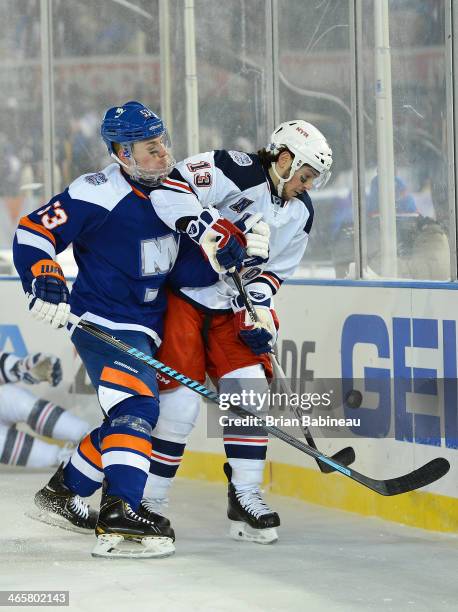 Daniel Carcillo of the New York Rangers and Casey Cizikas of the New York Islanders fight for the puck during the 2014 Coors Light NHL Stadium Series...