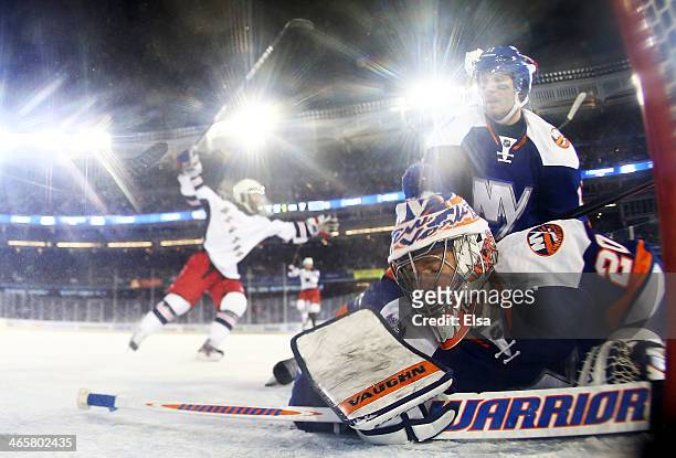 Evgeni Nabokov of the New York Islanders reacts after Benoit Pouliot of the New York Rangers scored a goal in the second period during the 2014 Coors...