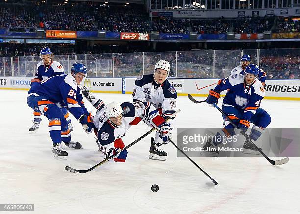 Derek Stepan and Chris Kreider of the New York Rangers battle for the puck against Brock Nelson and Andrew MacDonald of the New York Islanders during...