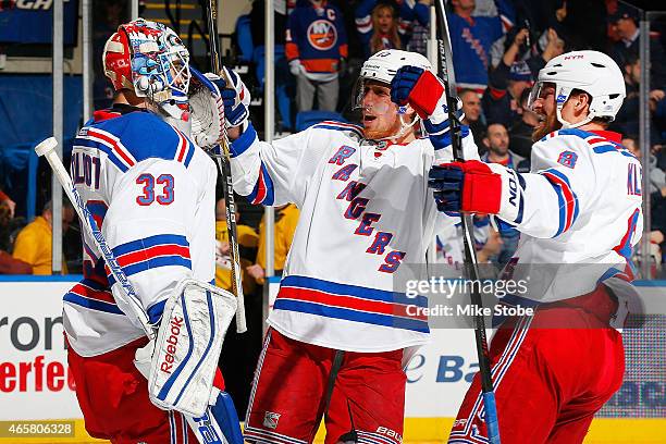 Cam Talbot of the New York Rangers is congratulated by his teammates Marc Staal and Kevin Klein after defeating the New York Islanders at Nassau...