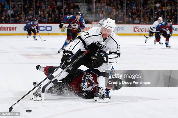 Jeff Carter of the Los Angeles Kings controls the puck as Matt Duchene of the Colorado Avalanche is penalized for tripping in the first period at...