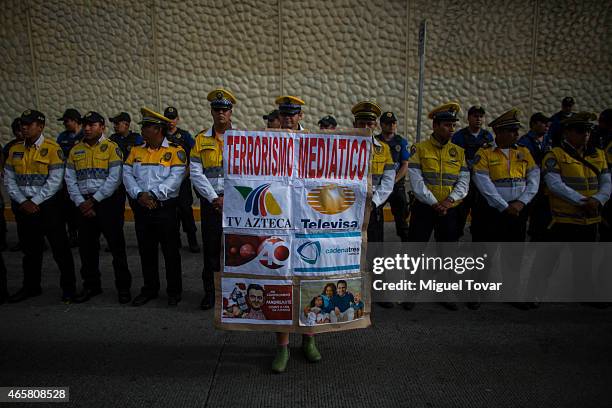 Woman holds a banner against mexican media as demonstrators and relatives of the 43 missing students from Ayotzinapa protest outside the Mexican...