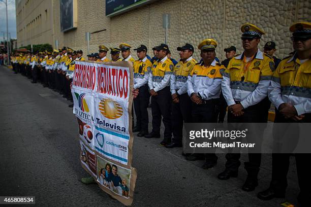 Woman holds a banner against mexican media as demonstrators and relatives of the 43 missing students from Ayotzinapa protest outside the Mexican...