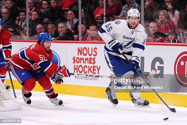 Braydon Coburn of the Tampa Bay Lightning skates with the puck while being chased by David Desharnais of the Montreal Canadiens during the NHL game...