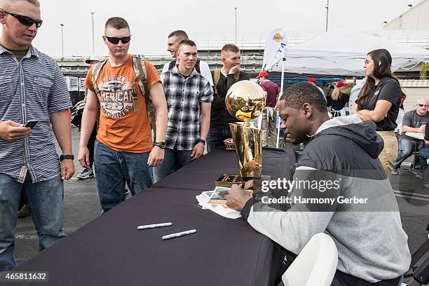 Los Angeles Laker Julius Randle autographs photos for U.S. Troops at the Bob Hope USO at LAX on March 10, 2015 in Los Angeles, California.