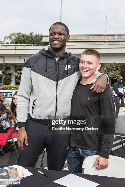 Los Angeles Laker Julius Randle autographs photos for U.S. Troops at the Bob Hope USO at LAX on March 10, 2015 in Los Angeles, California.