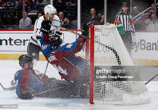 Jan Hejda and Tyson Barrie of the Colorado Avalanche crash into the goal as they defend an empty net against Jeff Carter of the Los Angeles Kings at...