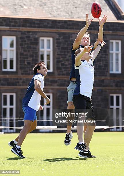 Formula One drivers Valterri Bottas and Felipe Massa contest for a football against AFL player Joel Selwood at Melbourne Grammar on March 11, 2015 in...