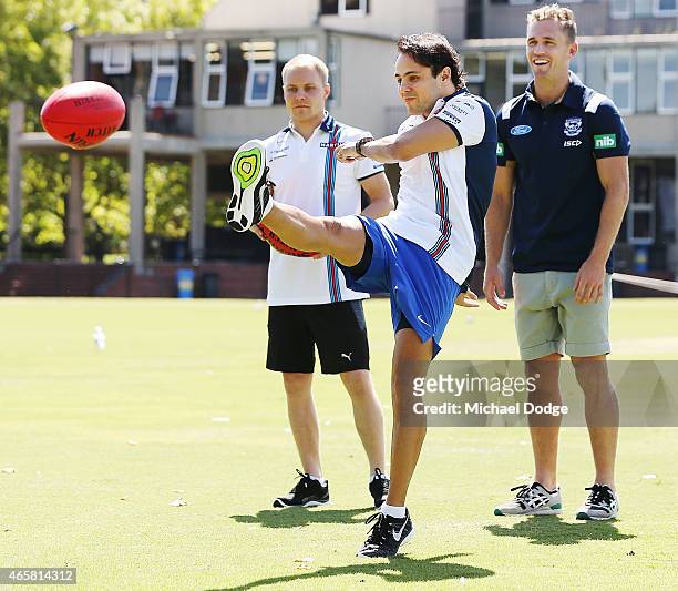 Formula One driver Felipe Massa kicks a football while meeting with AFL player Joel Selwood at Melbourne Grammar on March 11, 2015 in Melbourne,...