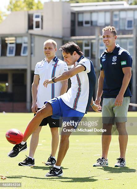 Formula One driver Felipe Massa kicks a football while meeting with AFL player Joel Selwood at Melbourne Grammar on March 11, 2015 in Melbourne,...