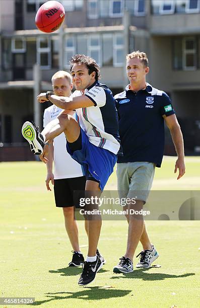 Formula One driver Felipe Massa kicks a football while meeting with AFL player Joel Selwood at Melbourne Grammar on March 11, 2015 in Melbourne,...