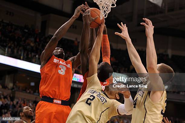 Jerami Grant and Baye Moussa Keita of the Syracuse Orange fight for a rebound against Devin Thomas of the Wake Forest Demon Deacons at Lawrence Joel...