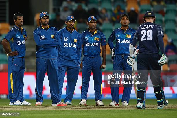 Sri Lankan team watch the replay on the big screen after sucessfully using a DRS challenge to take the wicket of Michael Leask of Scotland during the...