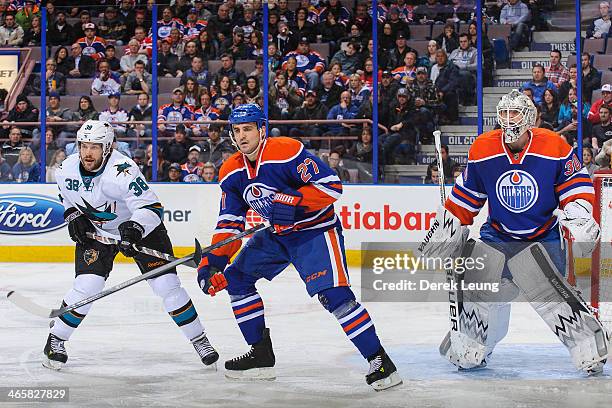 Boyd Gordon and Ben Scrivens of the Edmonton Oilers defend net against Bracken Kearns of the San Jose Sharks during an NHL game at Rexall Place on...