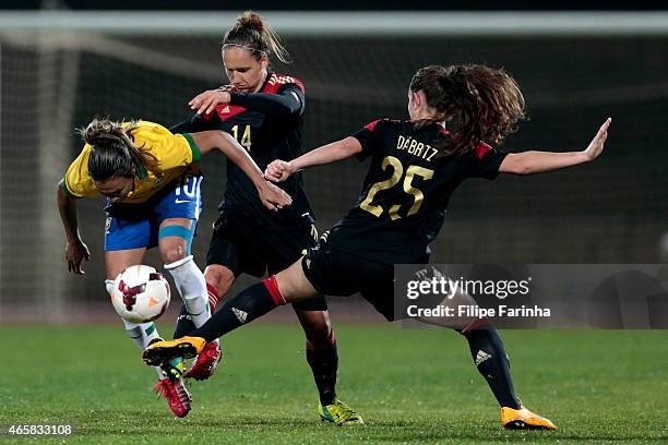 Marta Silva of Brazil challenges Babett Peter and Sara Dabritz of Germany during the Women's Algarve Cup match between Brazil and Germany on March 9,...