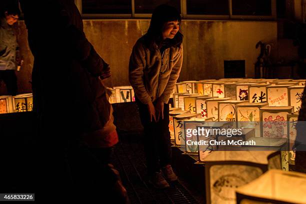 Young girl looks at paper lanterns during a memorial service for tsunami victims at the Yuriage Junior High School on March 11, 2015 in Natori,...