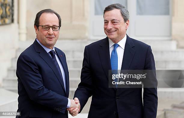 French President Francois Hollande welcomes Mario Draghi, president of the European Central Bank prior a meeting at the Elysee Palace on March 11,...