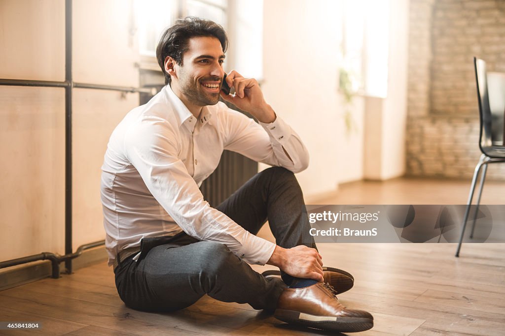 Uomo d'affari sorridente parlando sul telefono.