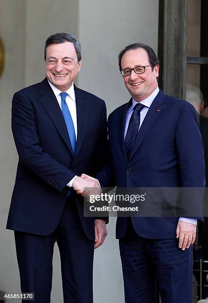 French President Francois Hollande accompanies Mario Draghi, president of the European Central Bank after their meeting at the Elysee Palace on March...